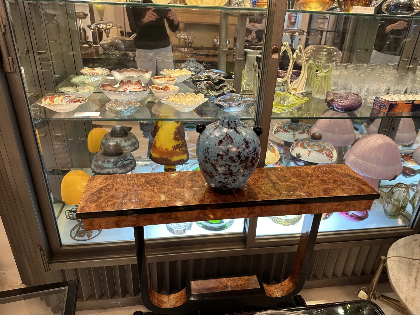 signed glass in a showcase with colorful antiques