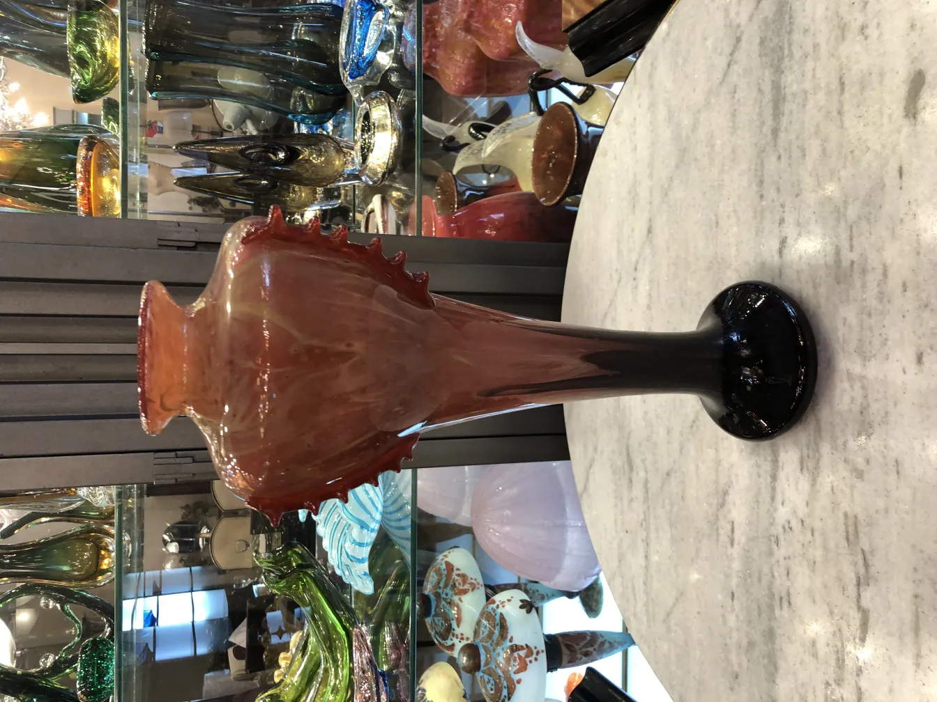 Antike Vase mit roten und schwarzen Details aus Glas, dekorativer Hintergrund mit Antiquitäten.