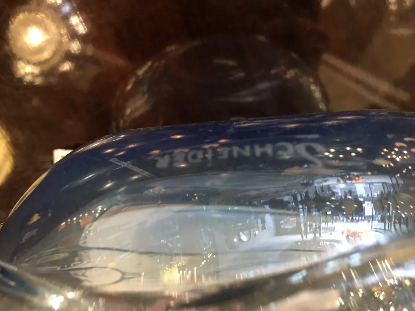 Nahaufnahme von signiertem Glas Schneider auf dunklem Hintergrund