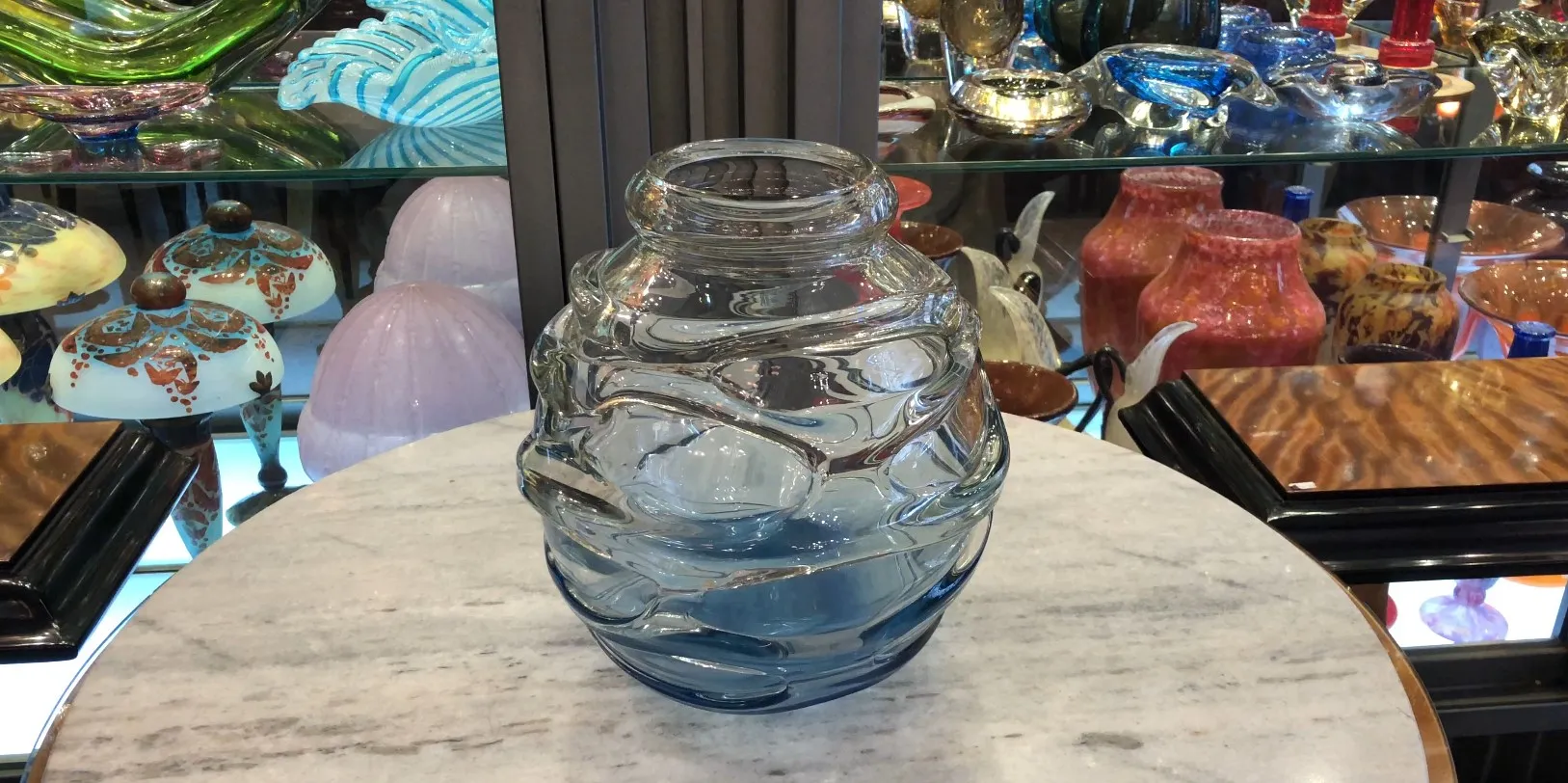 Antikes Glas mit Unterschrift von Schneider und auffälligem Design, ausgestellt in eleganter Umgebung.