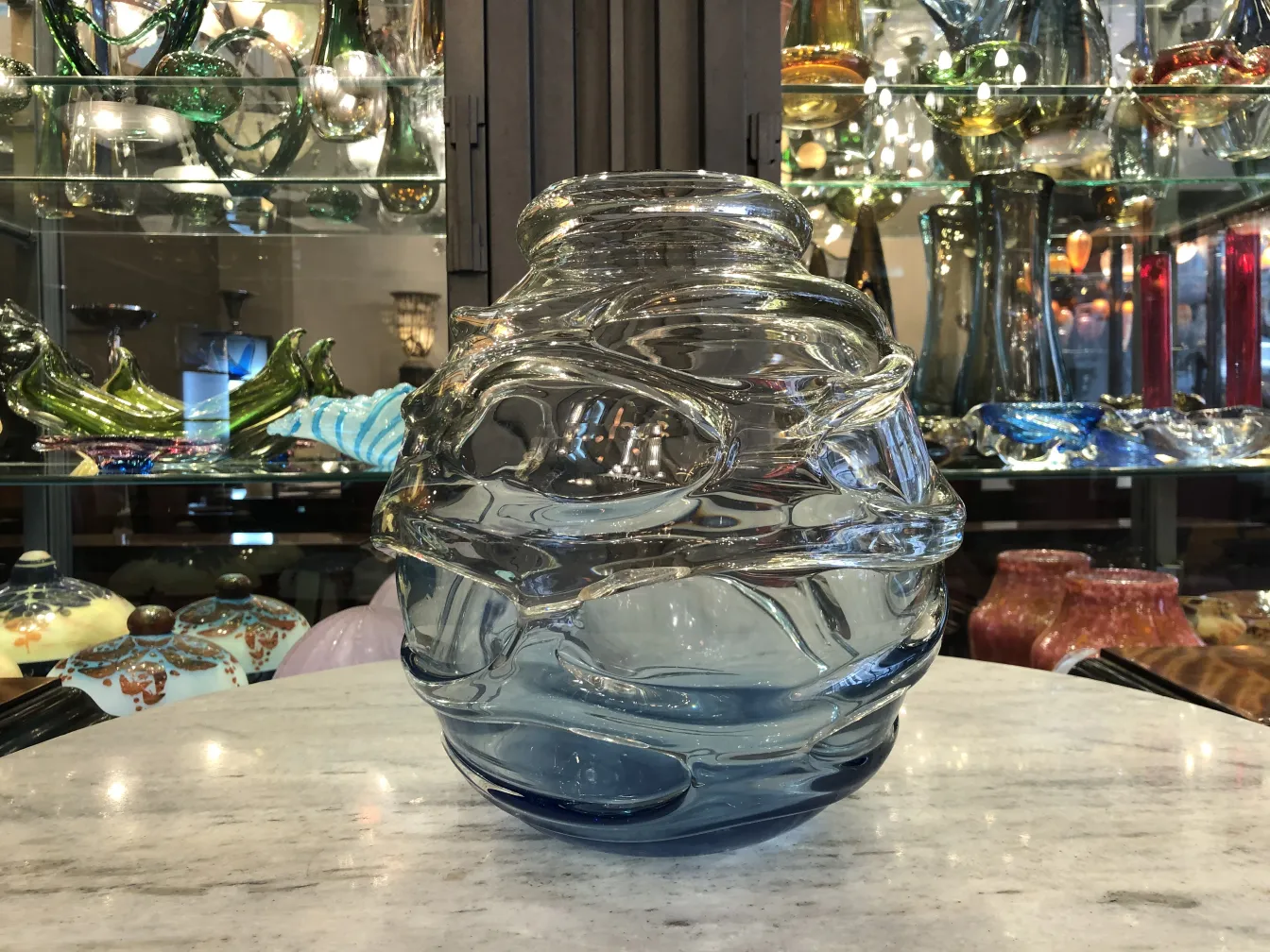 botella de vidrio firmado en tonos azules y transparentes, con decoración ondulada, fondo de antigüedades