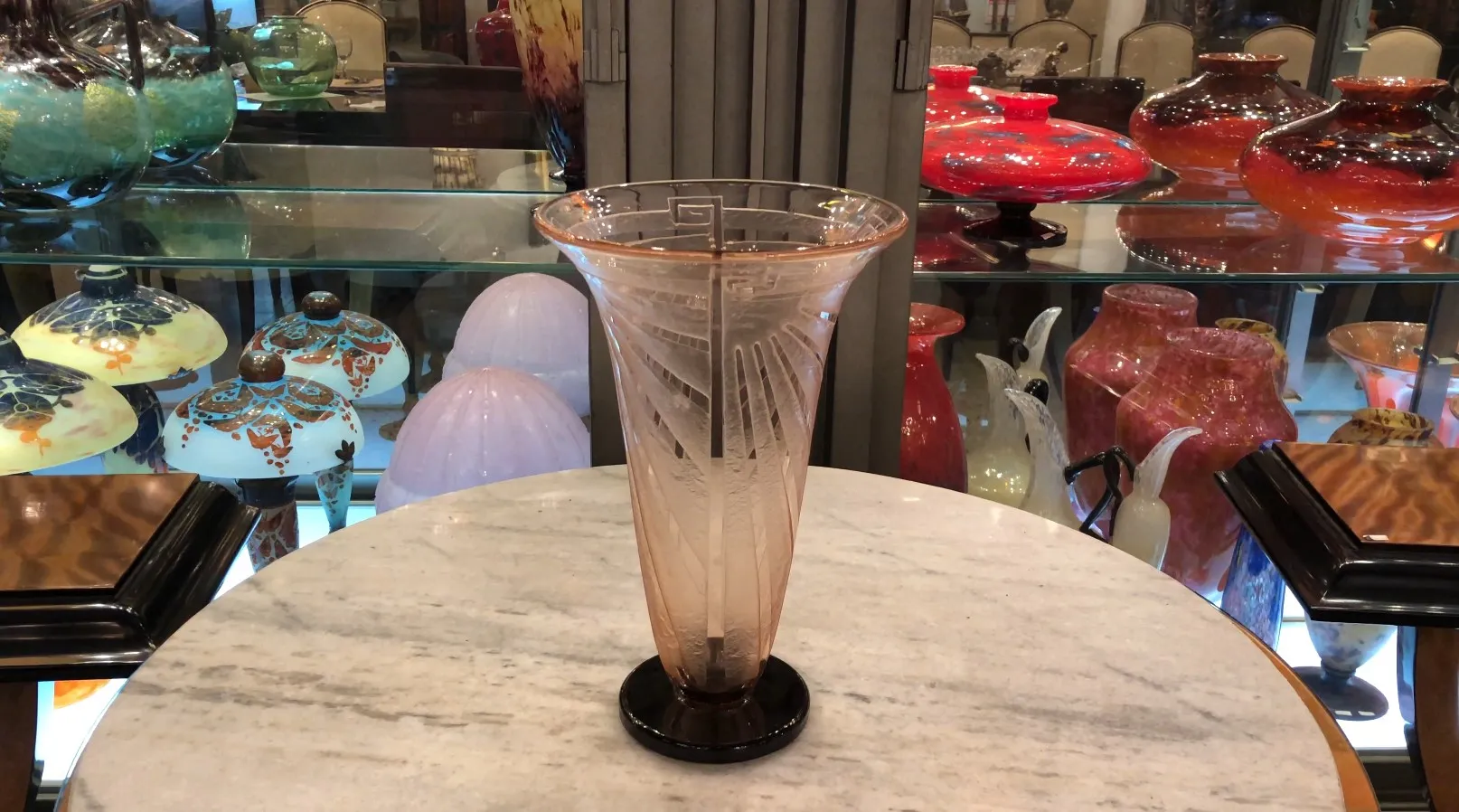 Vaso antiguo de vidrio con diseño decorativo de Schneider en un entorno vintage.