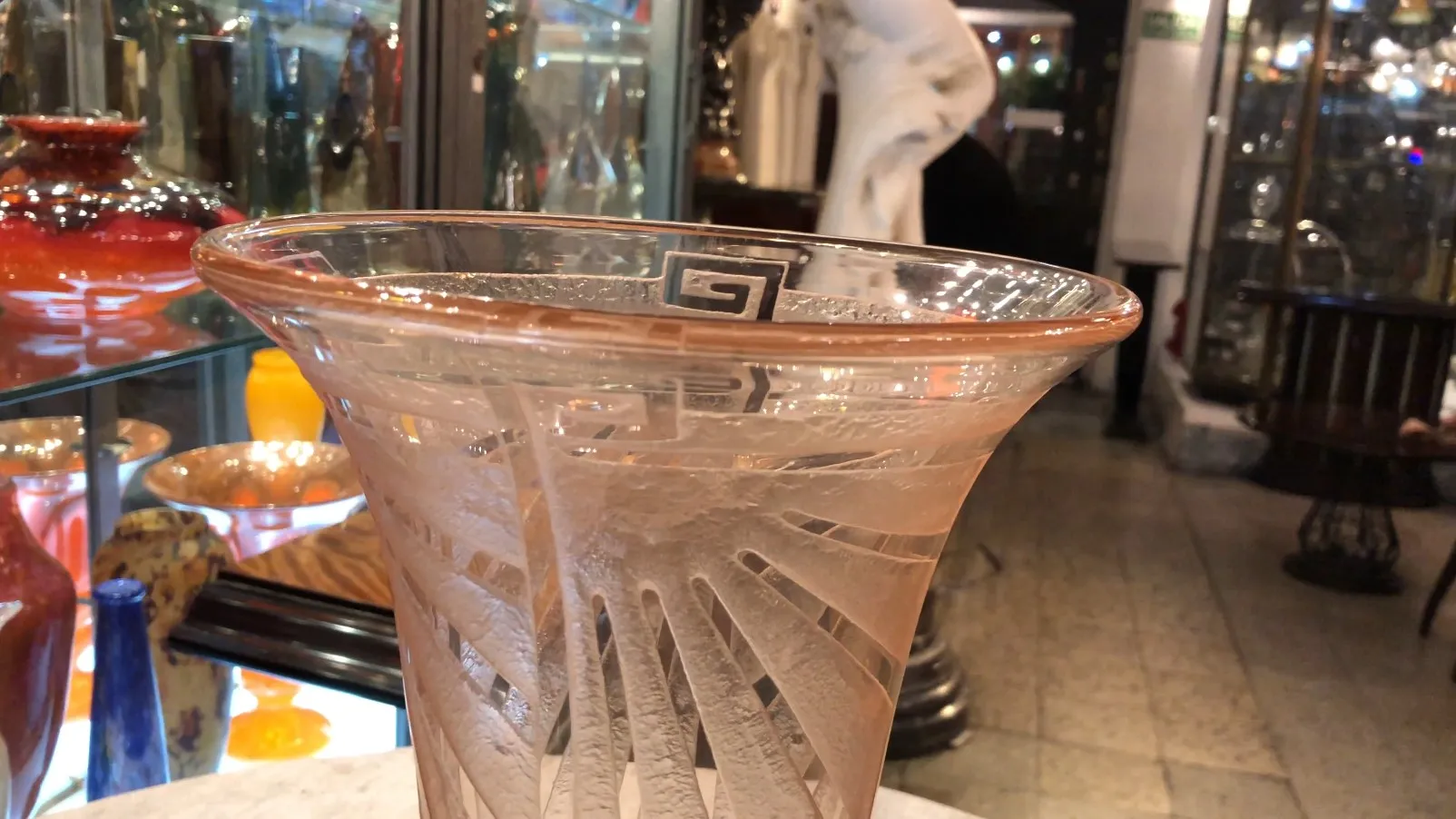 vaso antiguo con firma, fondo colorido de otros objetos