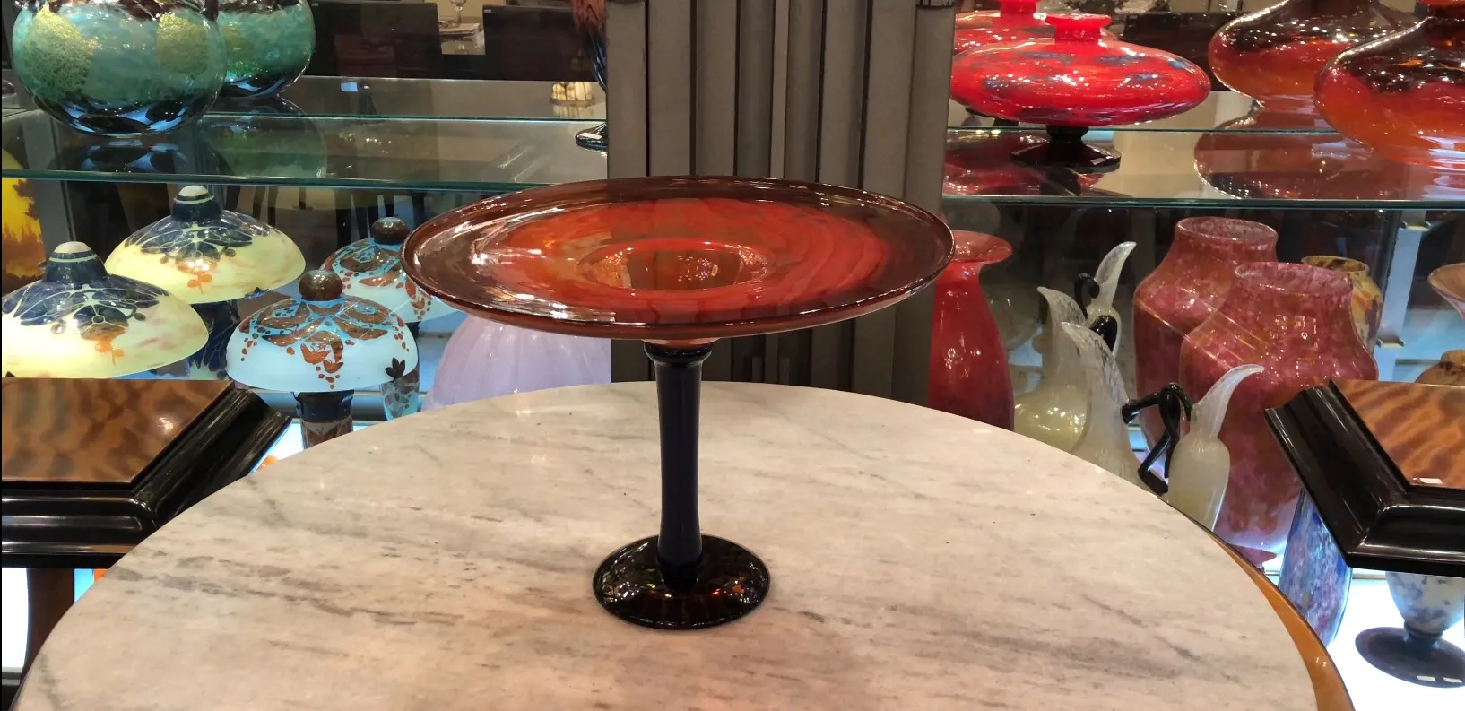 signed glass with a black base standing on a table