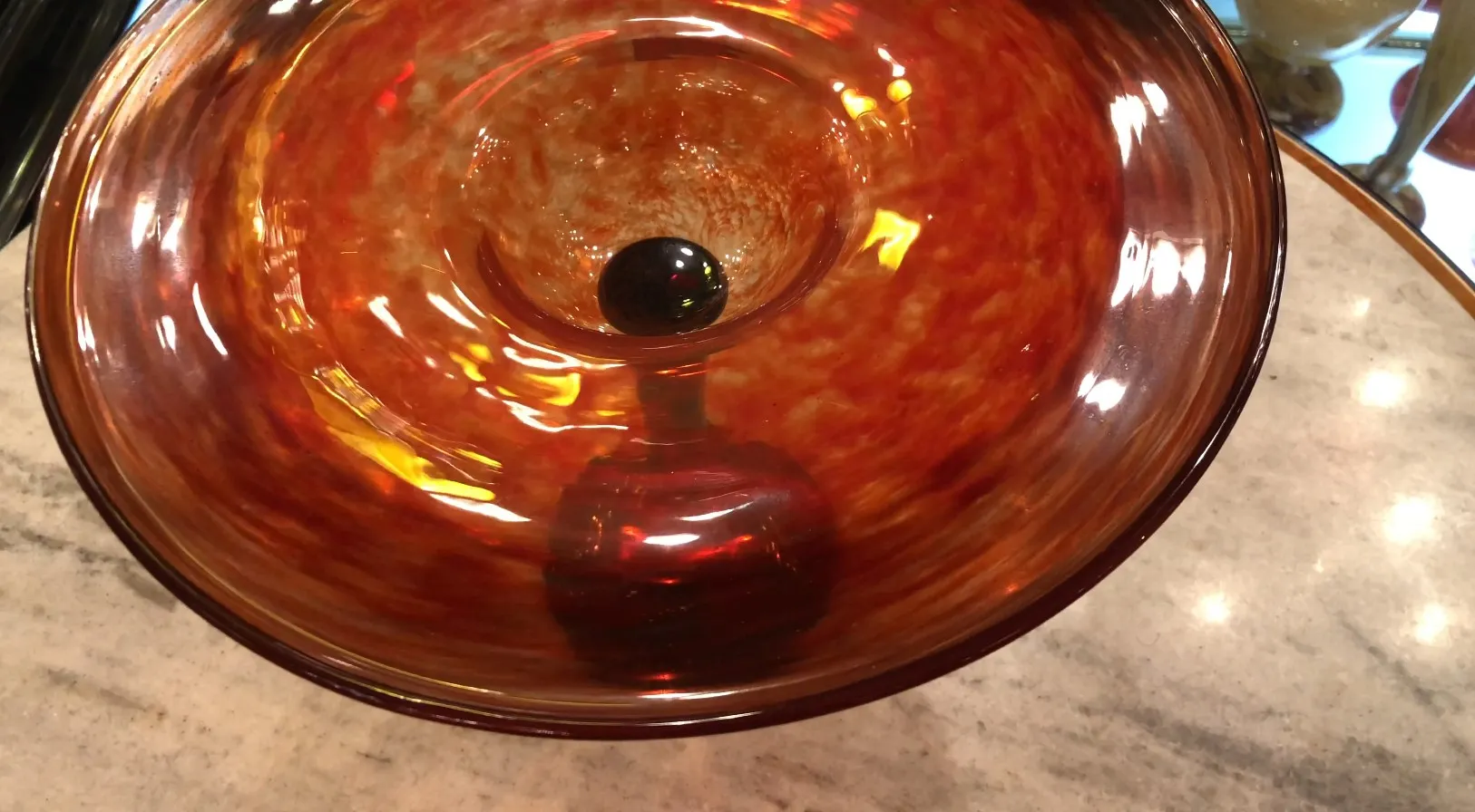 Glass with Schneider signature in orange hues, appealing background.