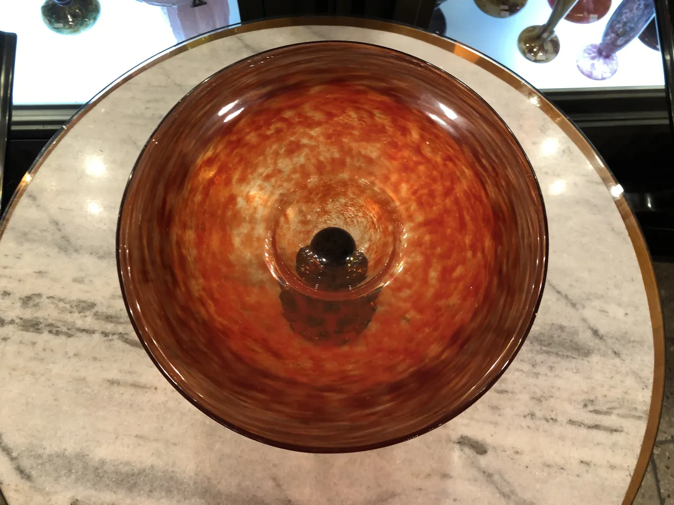 Aerial view of a beautiful signed glass Schneider with warm tones in the light.