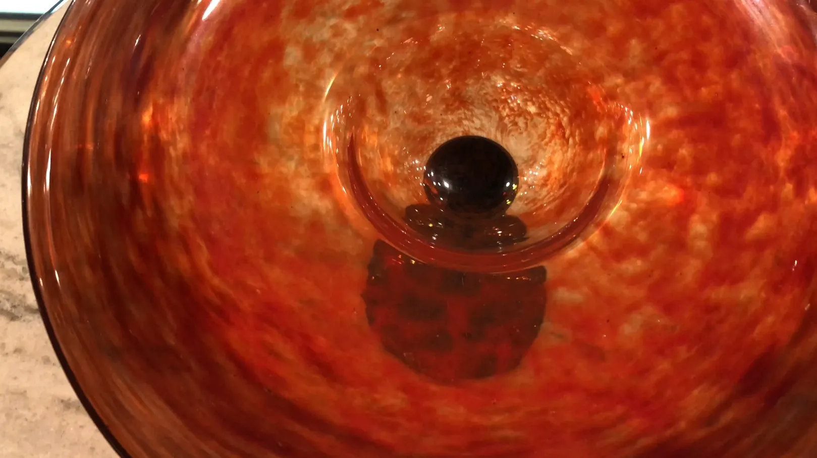 Vista interna de um vidro assinado Schneider antigo com tons quentes.