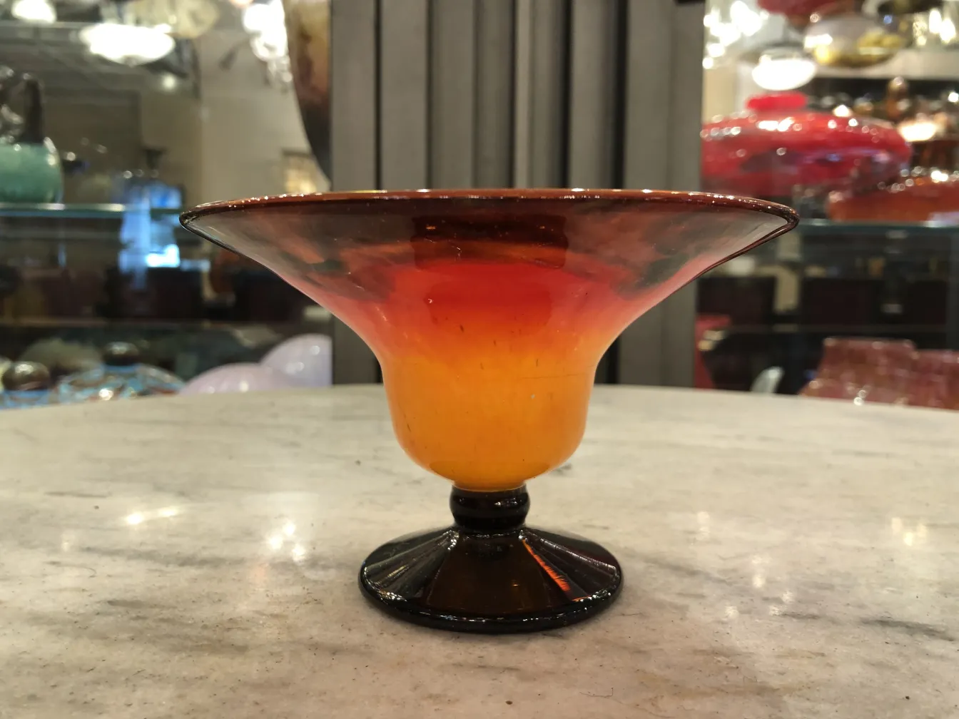 Handgefertigtes Glas mit Schneider-Unterschrift in orange-gelben Tönen