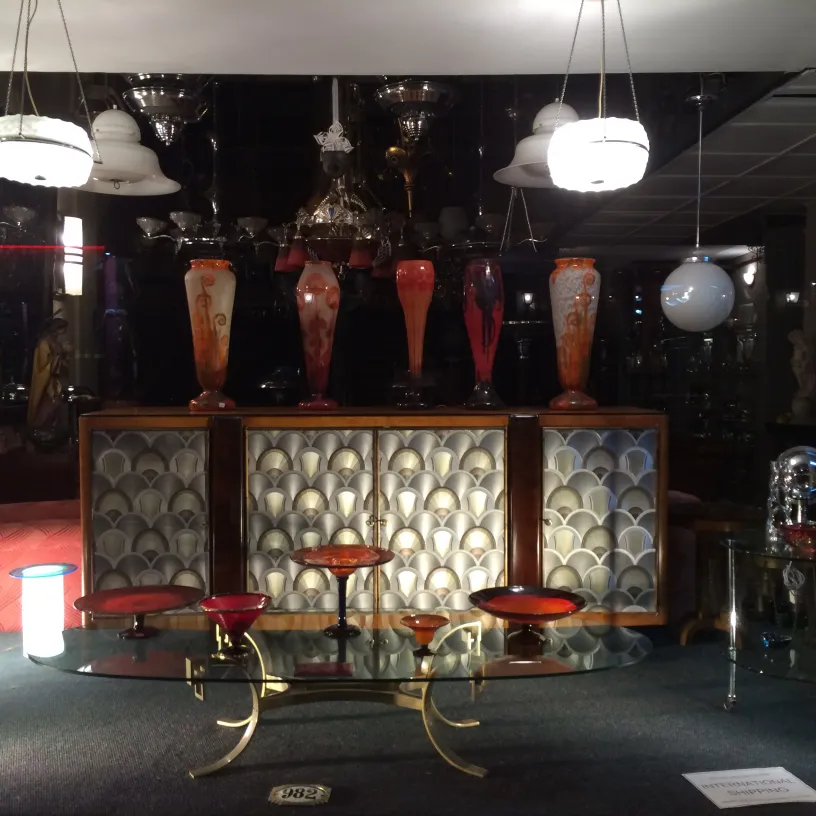 Antigüedades con vidrio firmado Schneider en ambiente elegante con luces