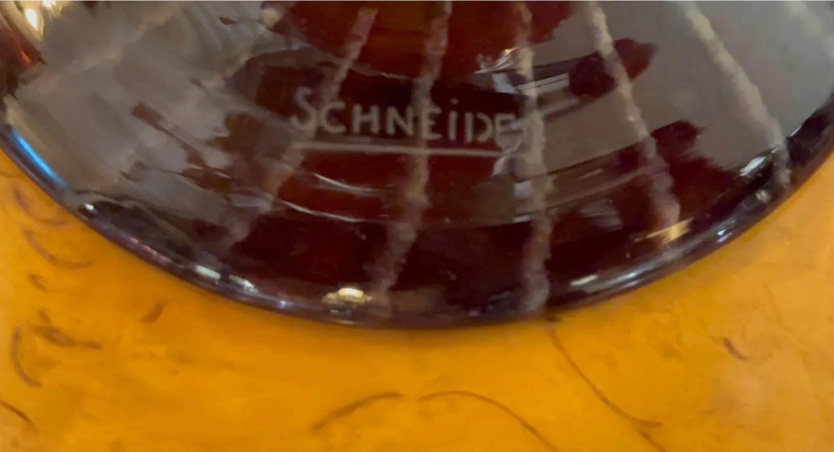 Vetro firmato da Schneider con colori ricchi e design elegante, vista laterale.