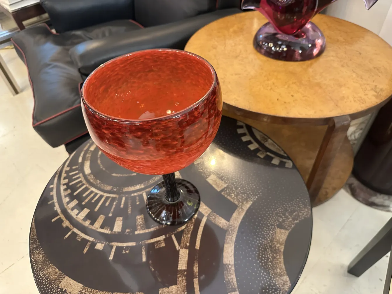 Vidro assinado vermelho em pedestal preto, ambiente elegante