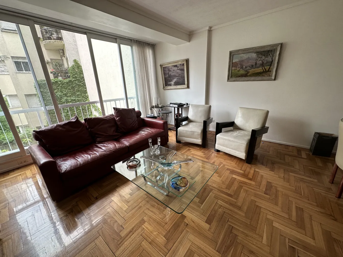 sillón y sofá en una sala con cristal de murano sobre la mesa