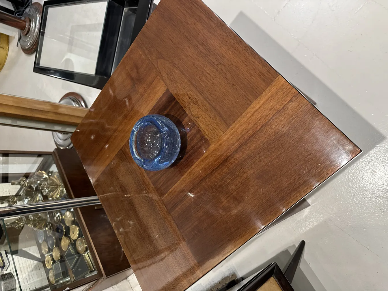 frente a una mesa de madera con un cristal de murano azul