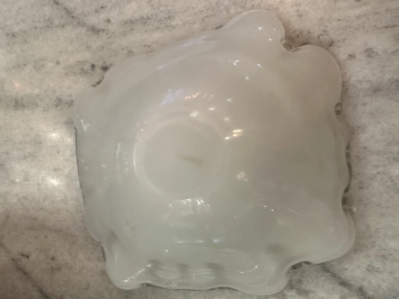 antique murano glass plate, round shape with wavy edges on marble