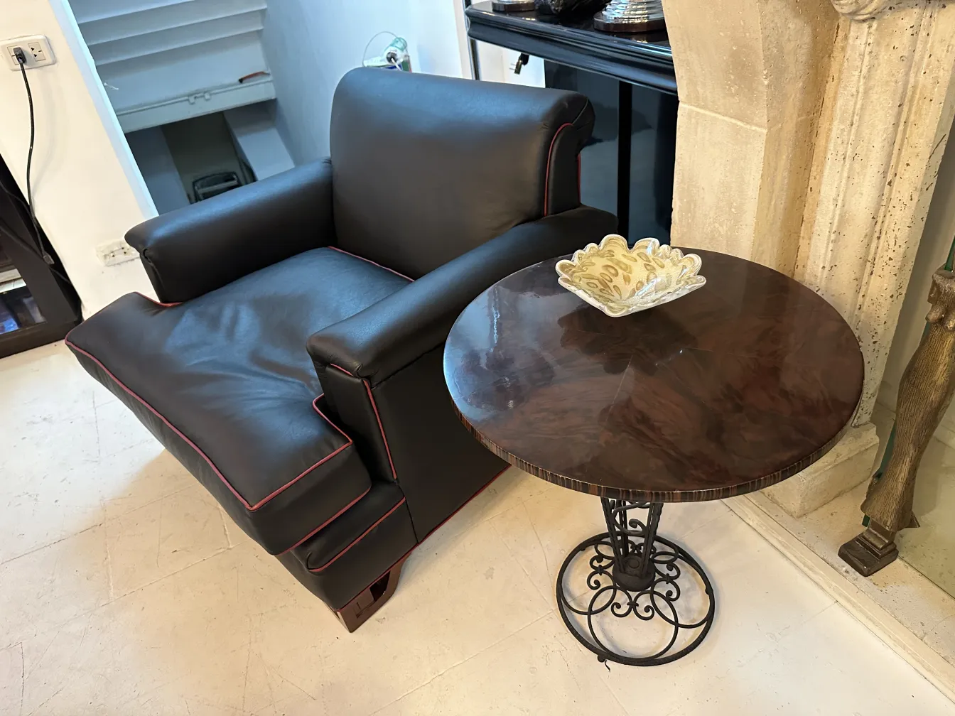 fauteuil noir avec coussins et table basse avec détail en verre