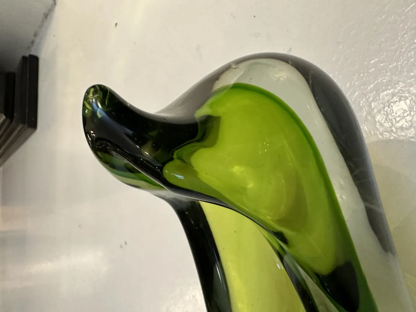 an elegant murano glass in green and black tones with a stylized shape