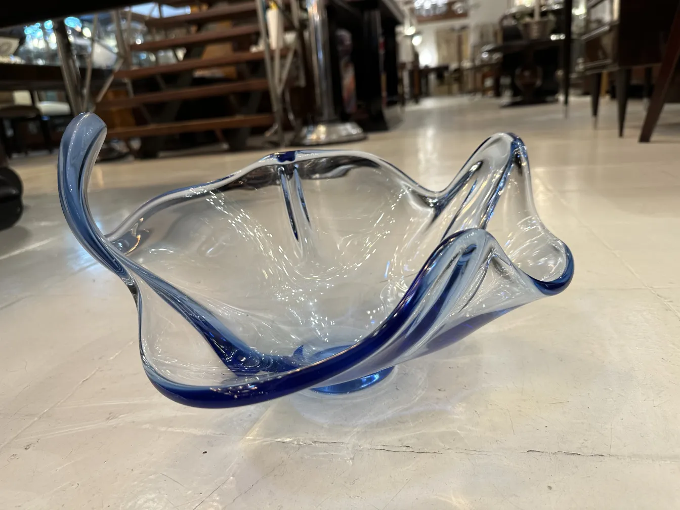 Jarrón antiguo de cristal de Murano con formas elegantes y detalles azules, colocado en un entorno de antigüedades