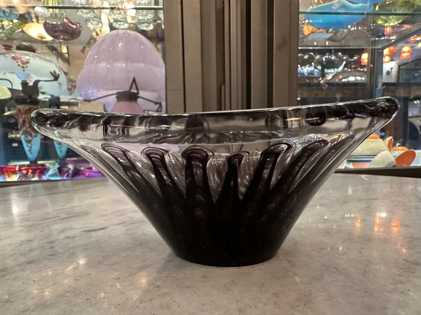 bowl de cristal de murano con patrón en forma de ola, fondo negro, en un ambiente iluminado