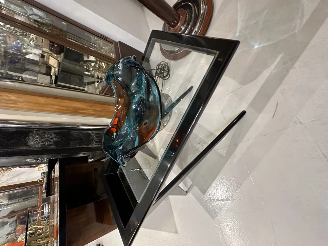 Cristal de Murano antigo em tons de azul e âmbar, em cima de mesa de vidro.