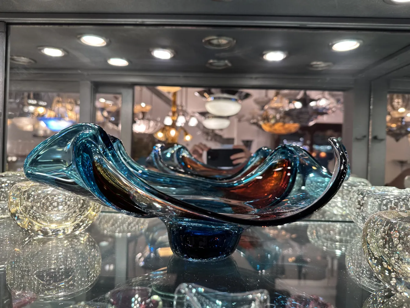 Antico vetro di Murano decorativo in tonalità blu e giallo in esposizione.