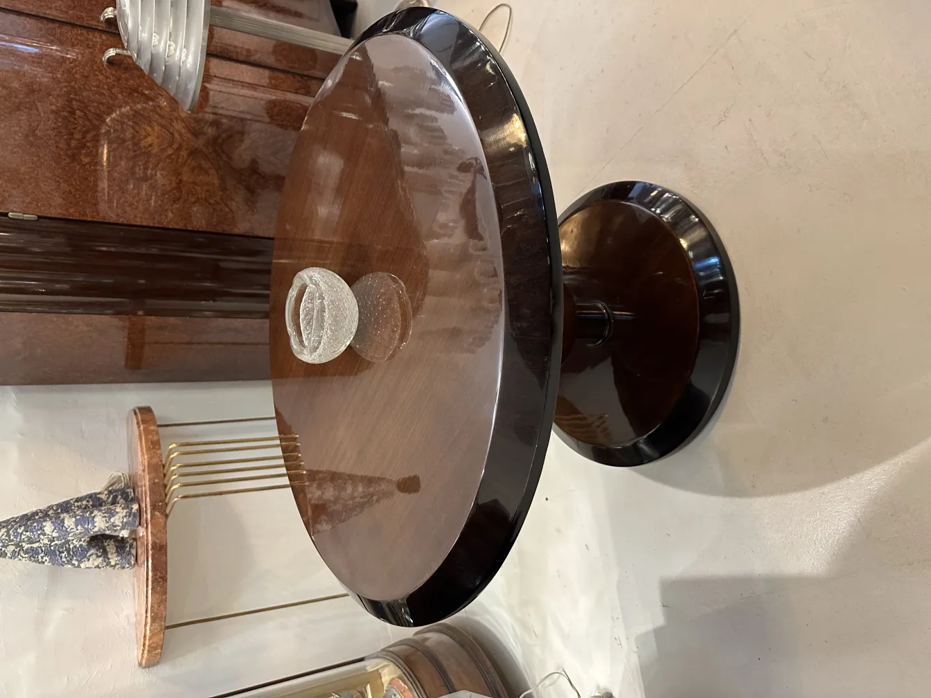 Mesa antiga com superfície lustrosa e vaso decorativo no centro