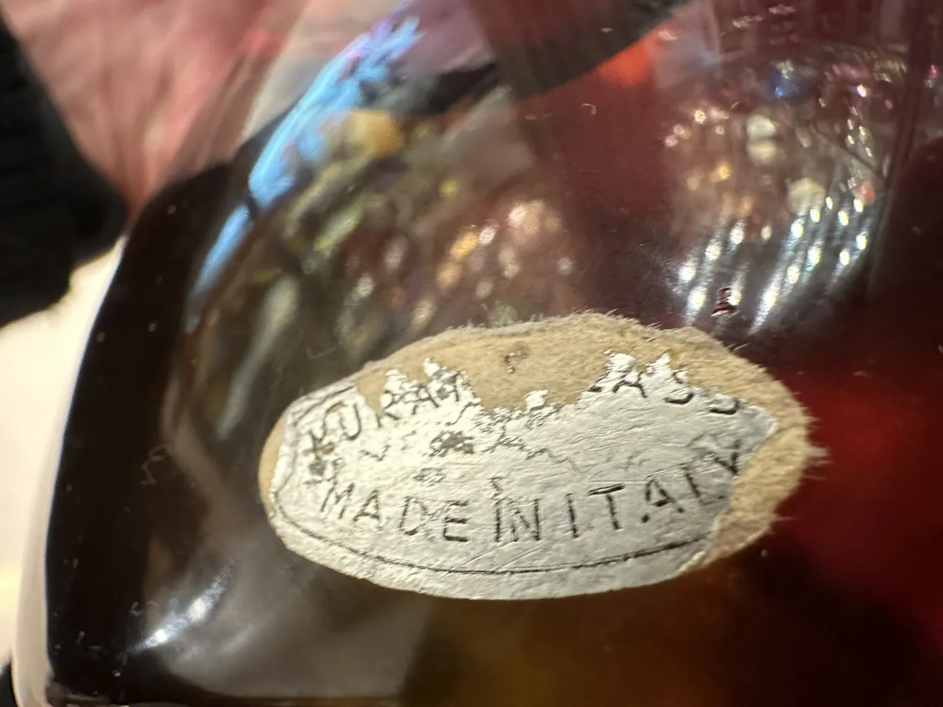 Antiguo cristal de Murano con una etiqueta en la base que dice Made in Italy, decorado en tonos cálidos.