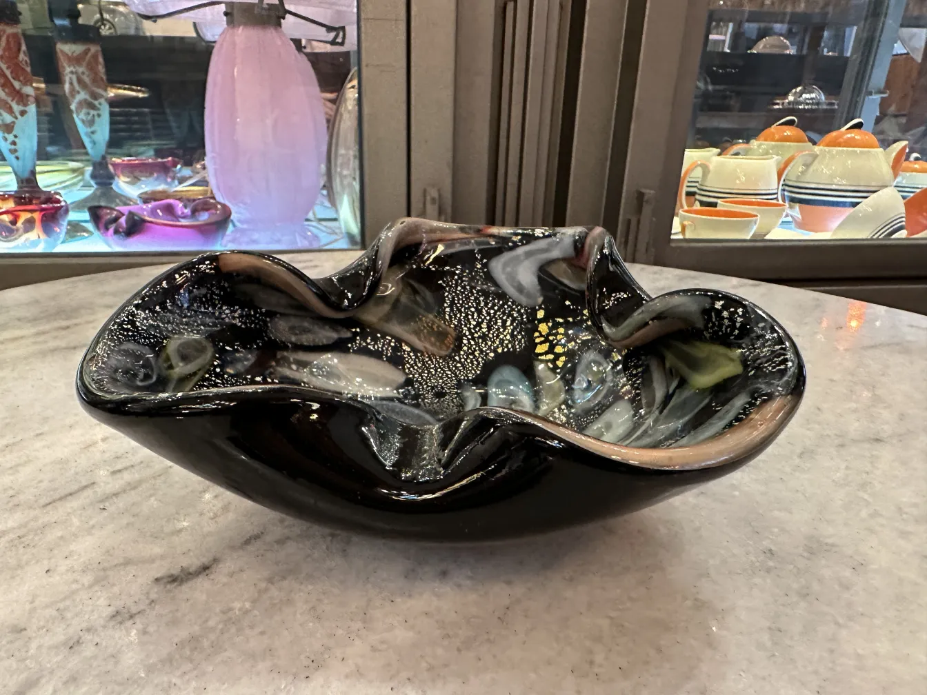 Bellissimo antico vaso in vetro di Murano con dettagli colorati e forme eleganti, ambientato in un contesto di antiquariato.