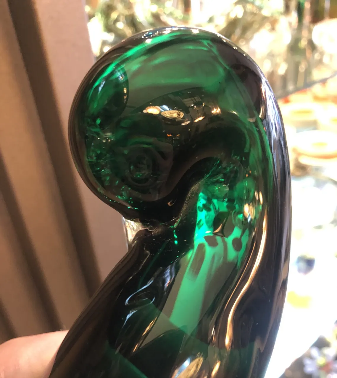 Cristal de Murano verde con forma curvada y detalles brillantes.