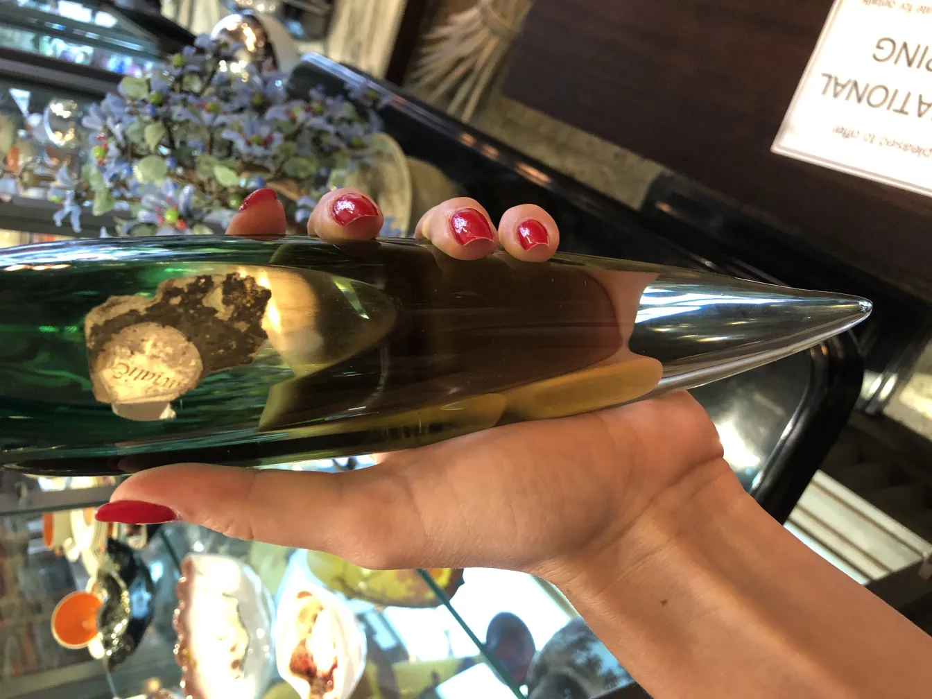 手中握着的绿色尖顶雕塑