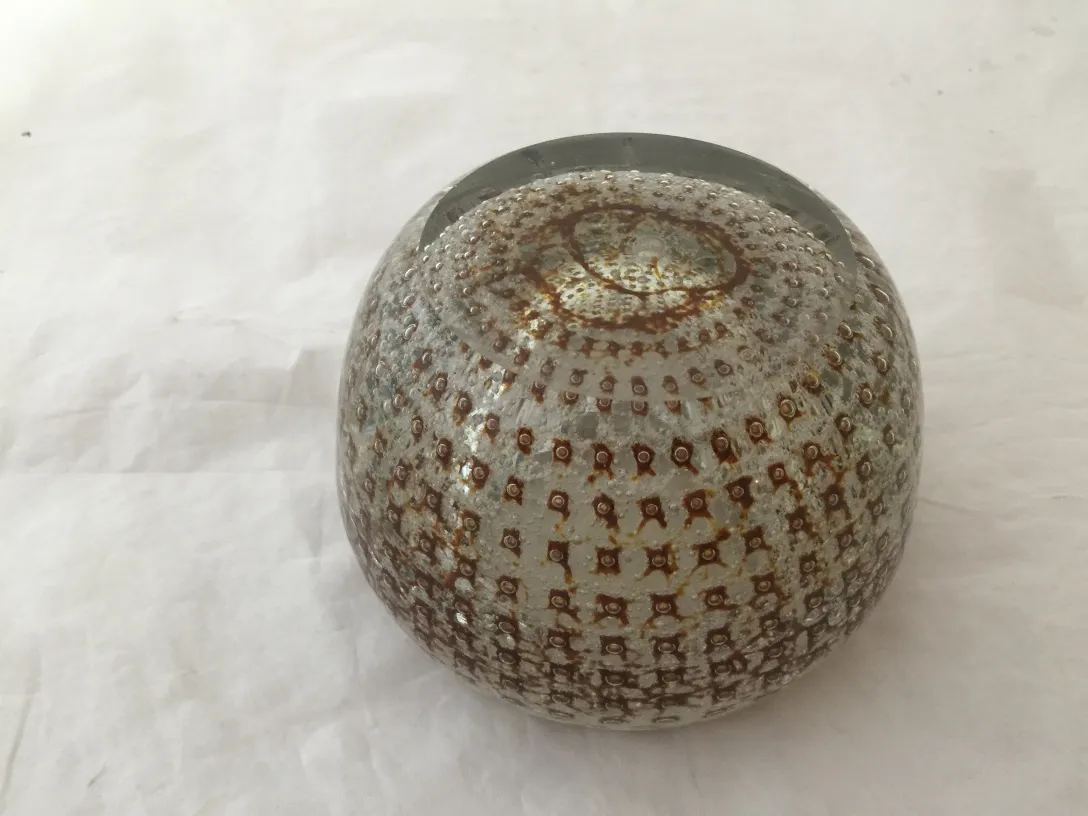 Sfera di vetro di Murano con dettagli marroni e superficie texture, su sfondo bianco.