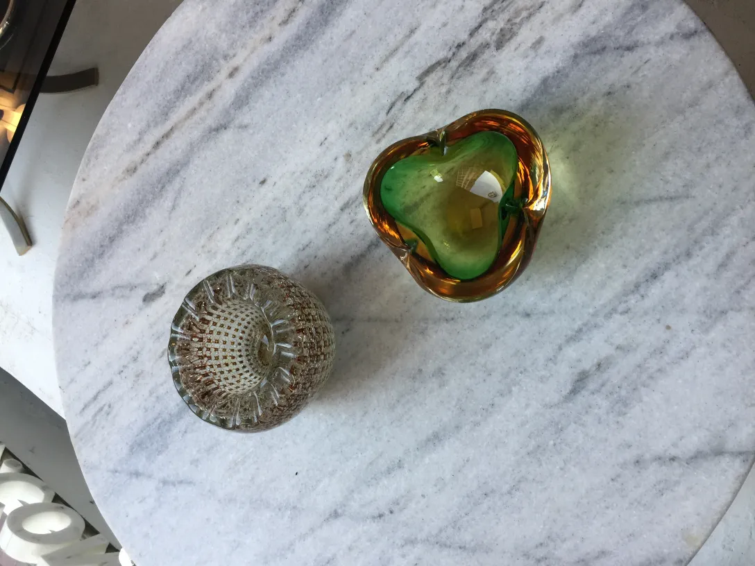 Cristal de Murano ancien en forme de cœur avec des couleurs vives et des détails décoratifs sur une table en marbre.