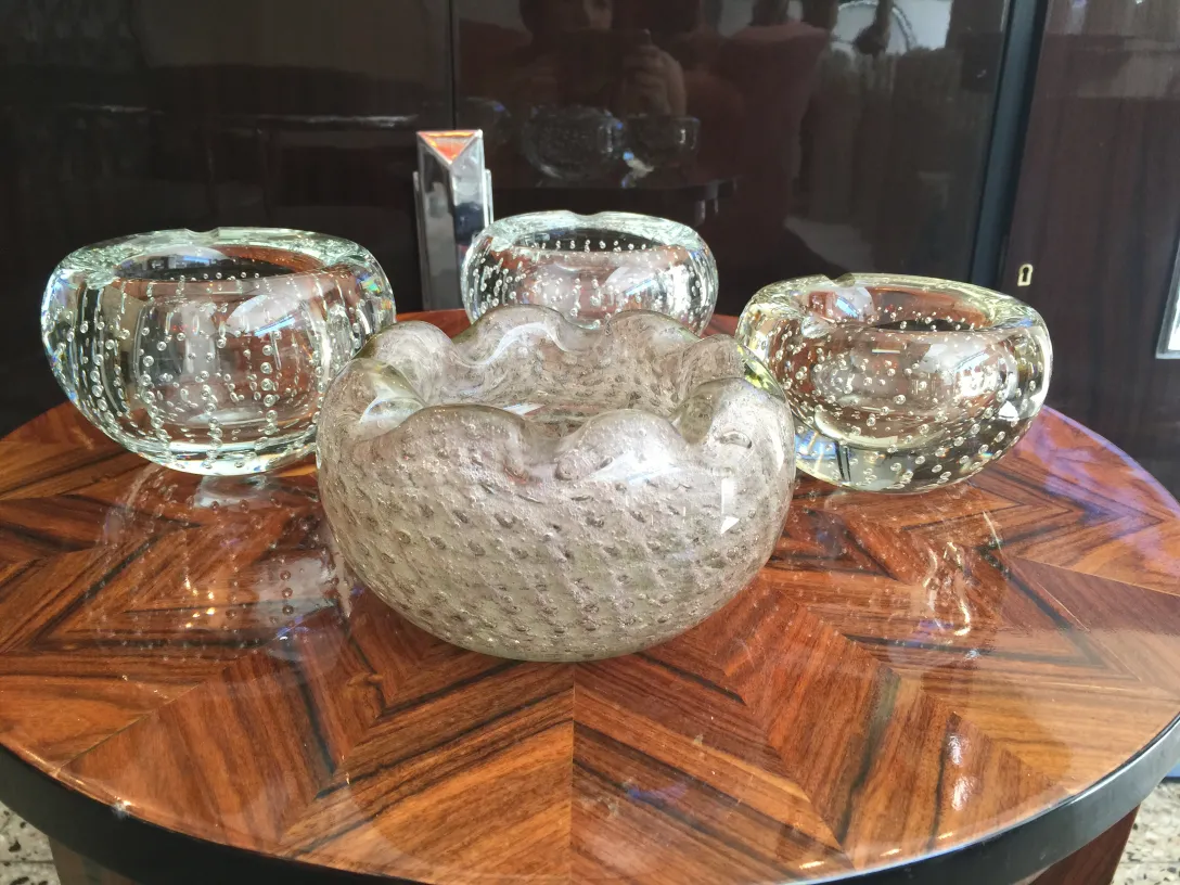 quatre pièces de cristal de murano sur une table en bois