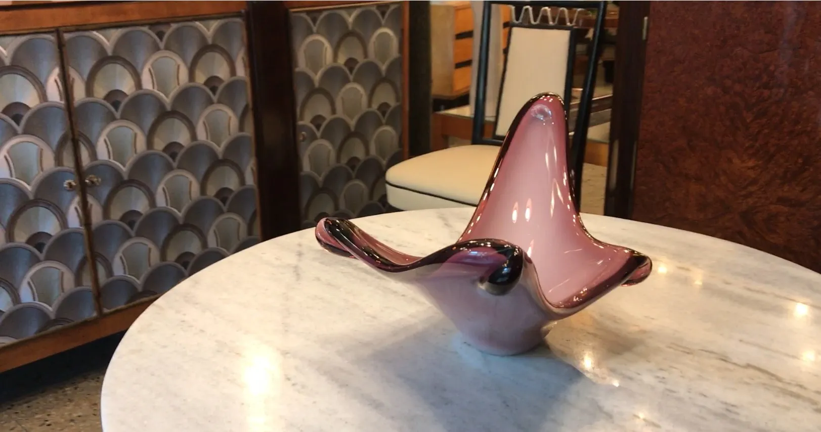 Pink Murano glass with wavy shape, elegant setting.