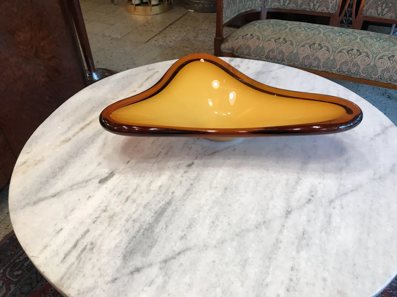 Antique Murano glass in amber tones and unique shape on marble table