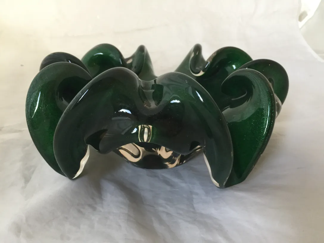 Beau cristal de Murano vert avec bords lisses et formes élégantes, dans un décor ancien.