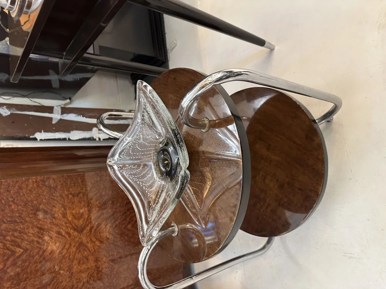 pezzo decorativo antico in vetro di Murano con forma elegante e lucentezza chiara, posizionato su un tavolo di legno.