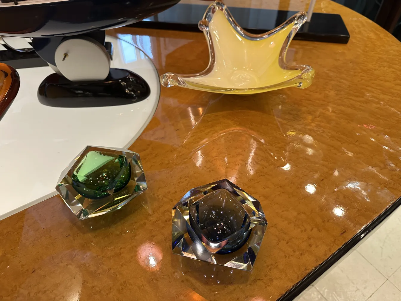 dois antigos cristais de murano em tons de verde e azul sobre a mesa