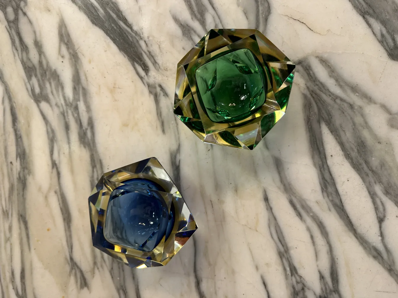 two antique murano glass pieces in blue and green on marble