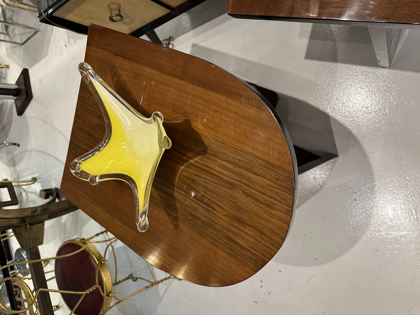 木製テーブルの上にある黄色の星型のムラーノガラス。