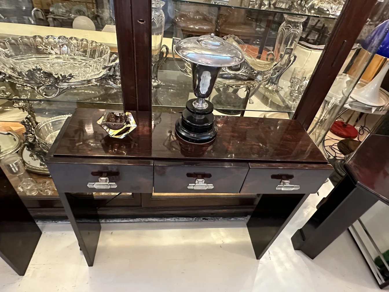 Antigo cristal de Murano em forma decorativa sobre mesa, cercado por outros itens antigos.