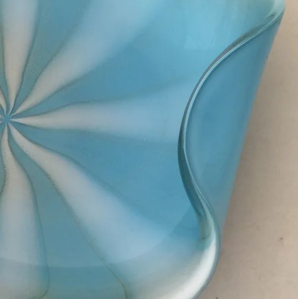 detalle de antiguo cristal de murano en azul claro con forma ondulada y patrones suaves