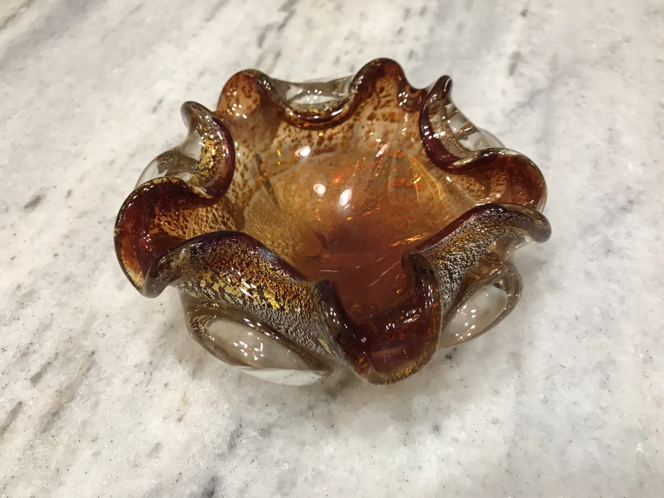 Antique Murano glass with wavy shapes and warm colors.