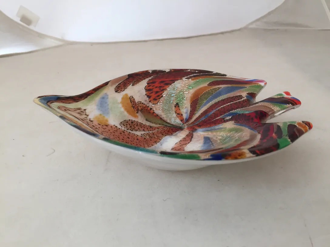 Antica figura in vetro di Murano con colori vivaci e forme eleganti in uno sfondo neutro.