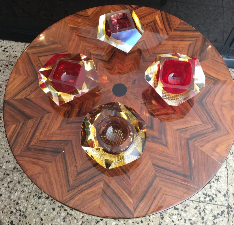 Cristais de Murano decorativos em várias cores sobre uma mesa.