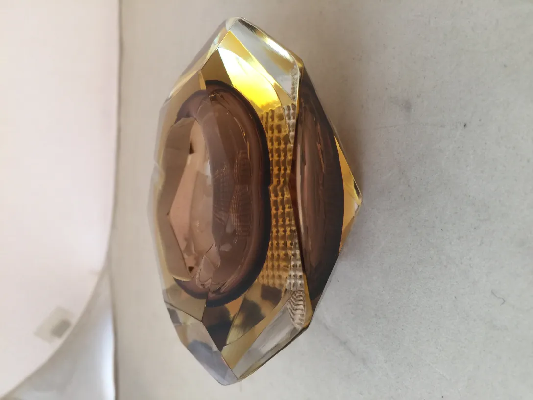 Cristal de Murano antigo decorado em tons dourados contra um fundo suave.