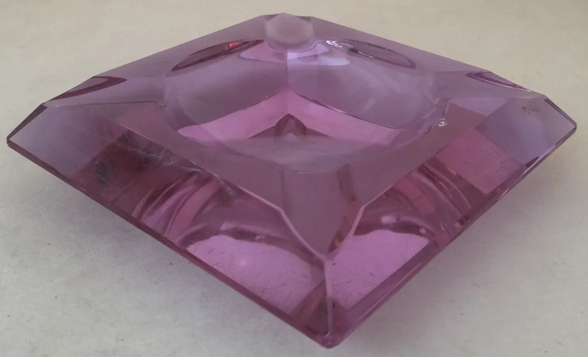 Cristal de Murano antiguo con forma angular y color rosado, ambiente elegante.