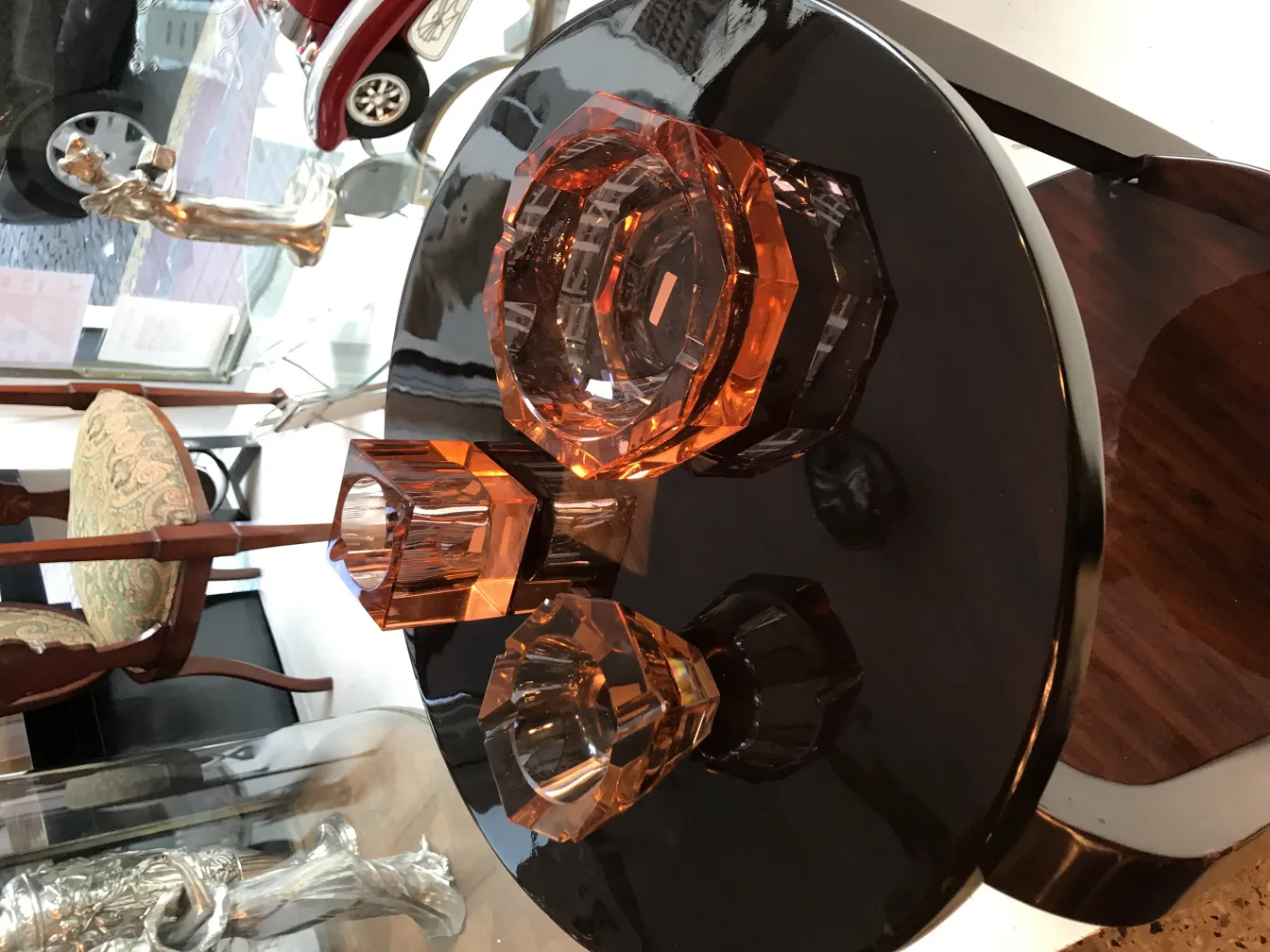 three pieces of murano glass in amber tones on a black table