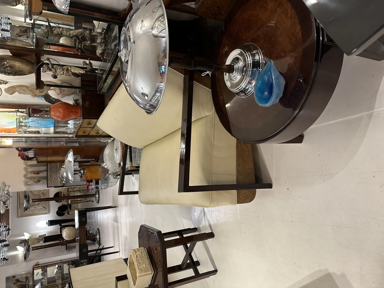 cadeira antiga ao lado de uma mesa com cristal de murano azul