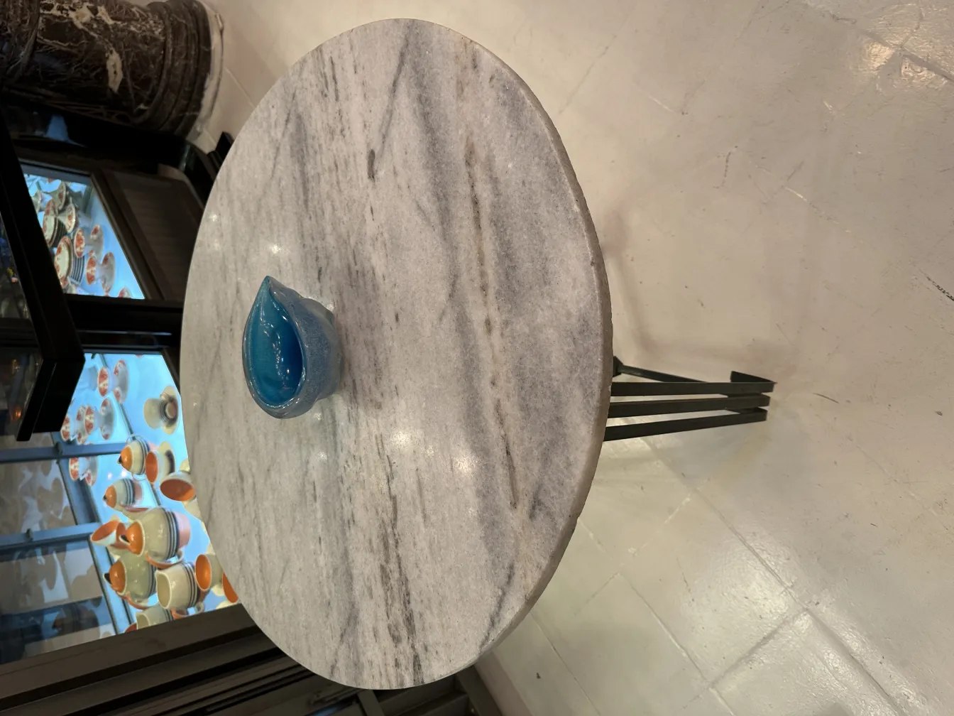 Cristal de Murano azul sobre mesa de mármol, ambiente elegante.