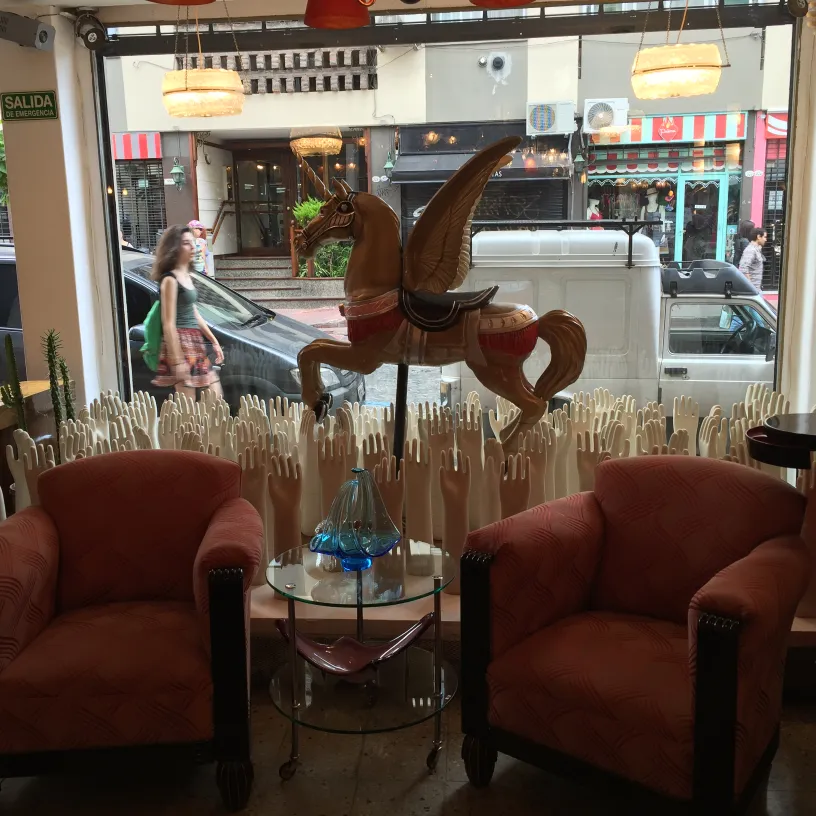 赤い椅子の隣のテーブルの上にある青いムラーノガラス